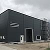 Die quadratische, schwarze Messhütte der Forschungsanlage von außen vor bewölktem Himmel.