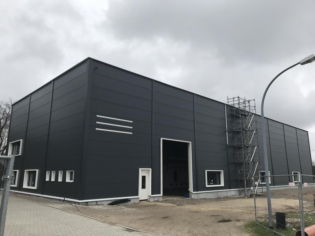 Die quadratische, schwarze Messhütte der Forschungsanlage von außen vor bewölktem Himmel.