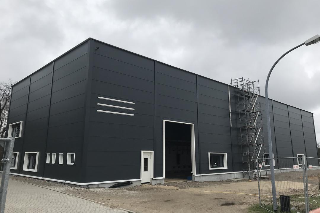 Die quadratische, schwarze Messhütte der Forschungsanlage von außen vor bewölktem Himmel.