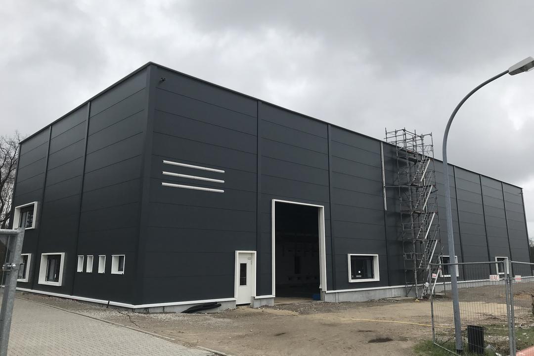 Die quadratische, schwarze Messhütte der Forschungsanlage von außen vor bewölktem Himmel.