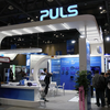 Ein Messestand von PULS mit Besuchern und Ausstellungsprodukten auf der Messe.