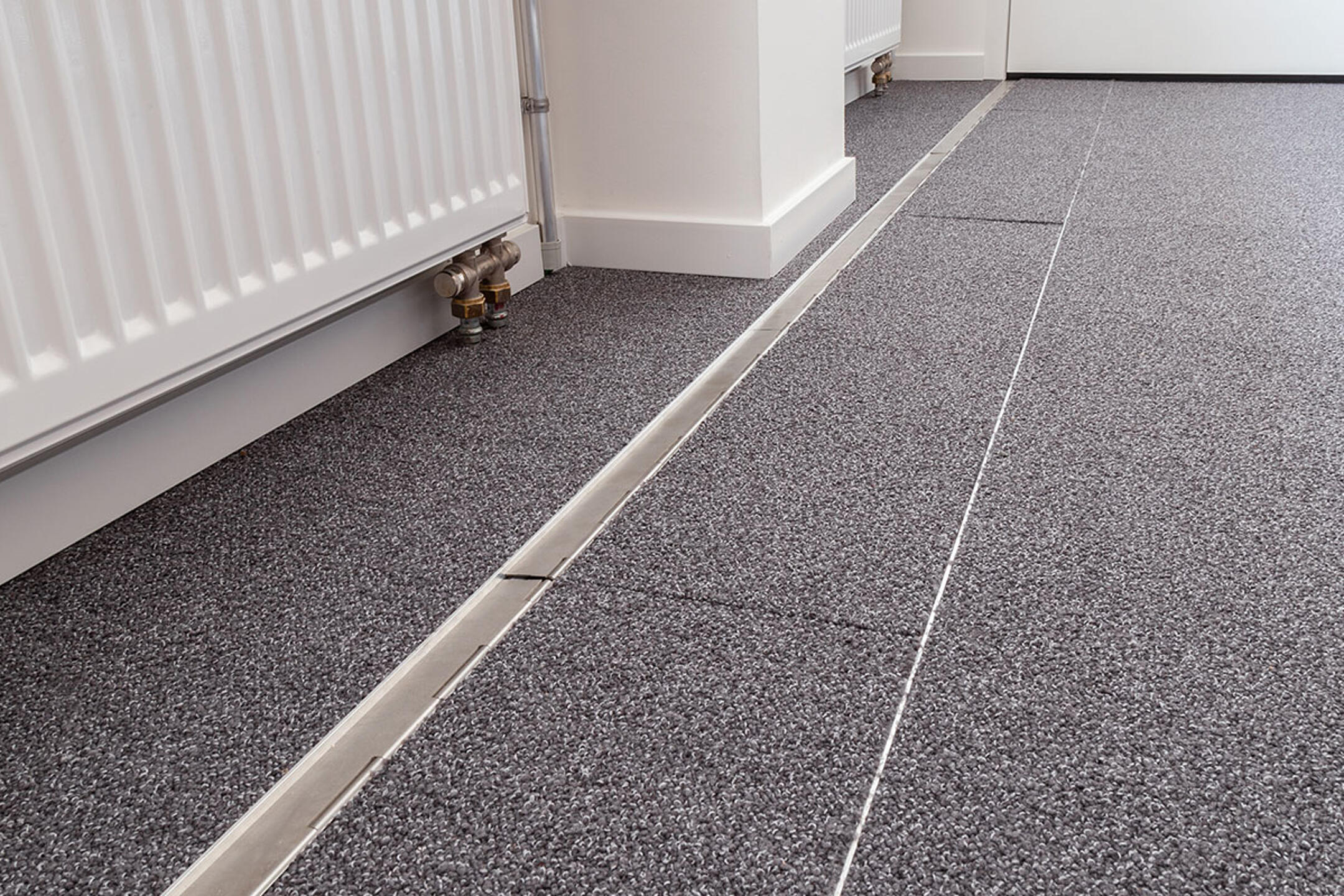Das in den Boden eingelassene Kanalsystem für Kabel, geschlossen, in einem Büro. Es ist sehr unauffällig.