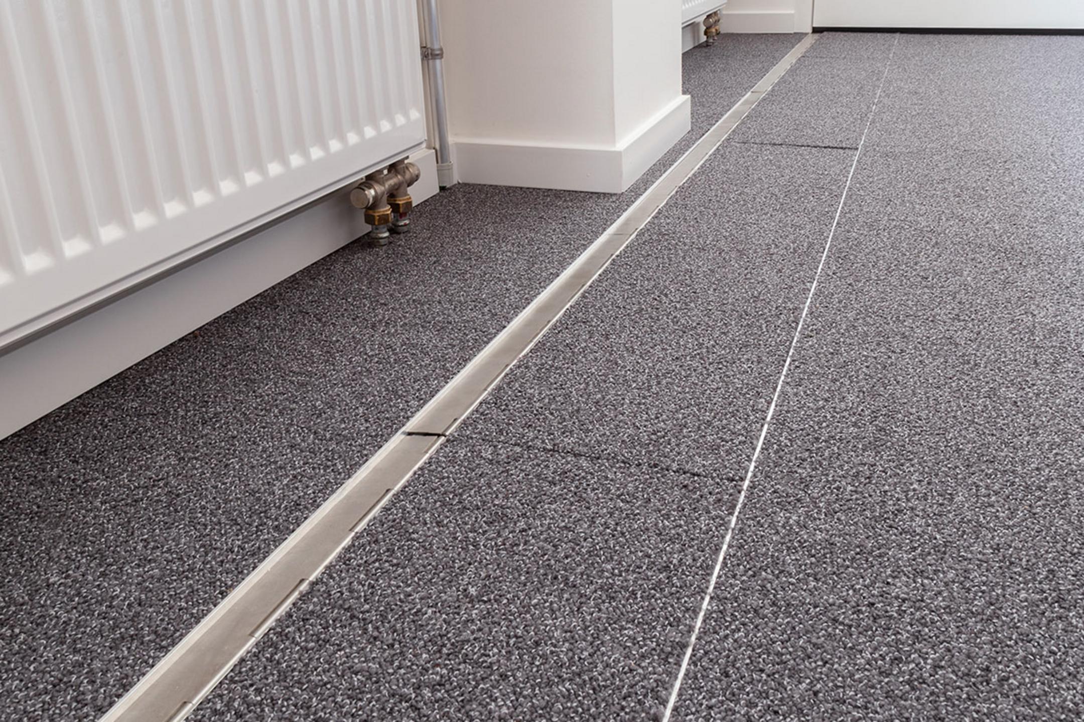 Das in den Boden eingelassene Kanalsystem für Kabel, geschlossen, in einem Büro. Es ist sehr unauffällig.