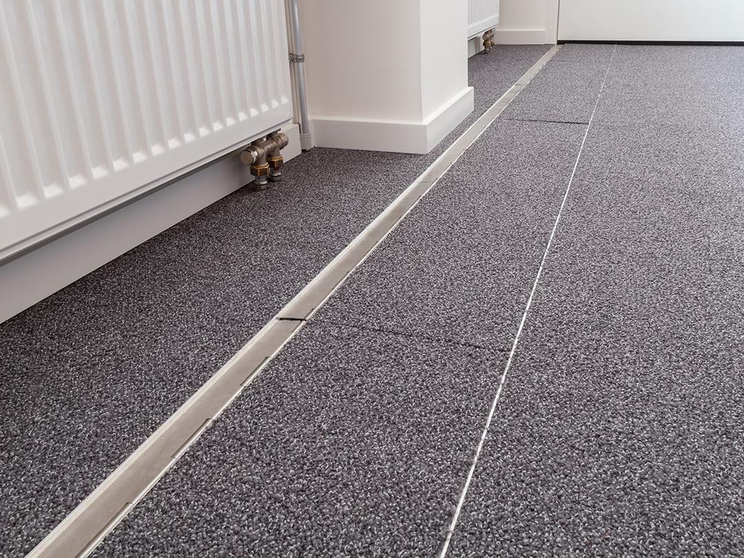 Das in den Boden eingelassene Kanalsystem für Kabel, geschlossen, in einem Büro. Es ist sehr unauffällig.