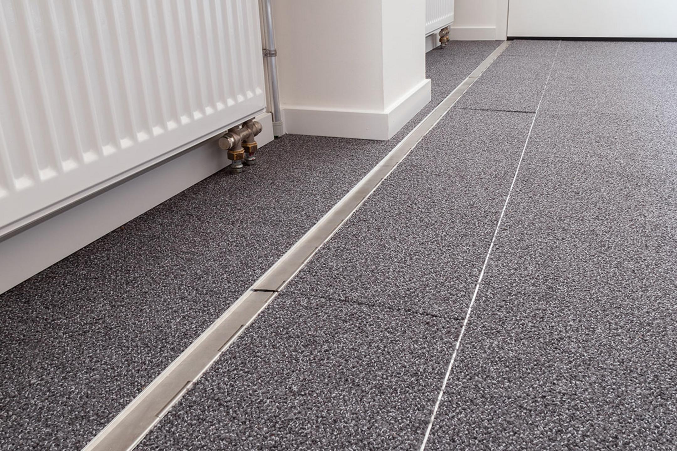 Das in den Boden eingelassene Kanalsystem für Kabel, geschlossen, in einem Büro. Es ist sehr unauffällig.