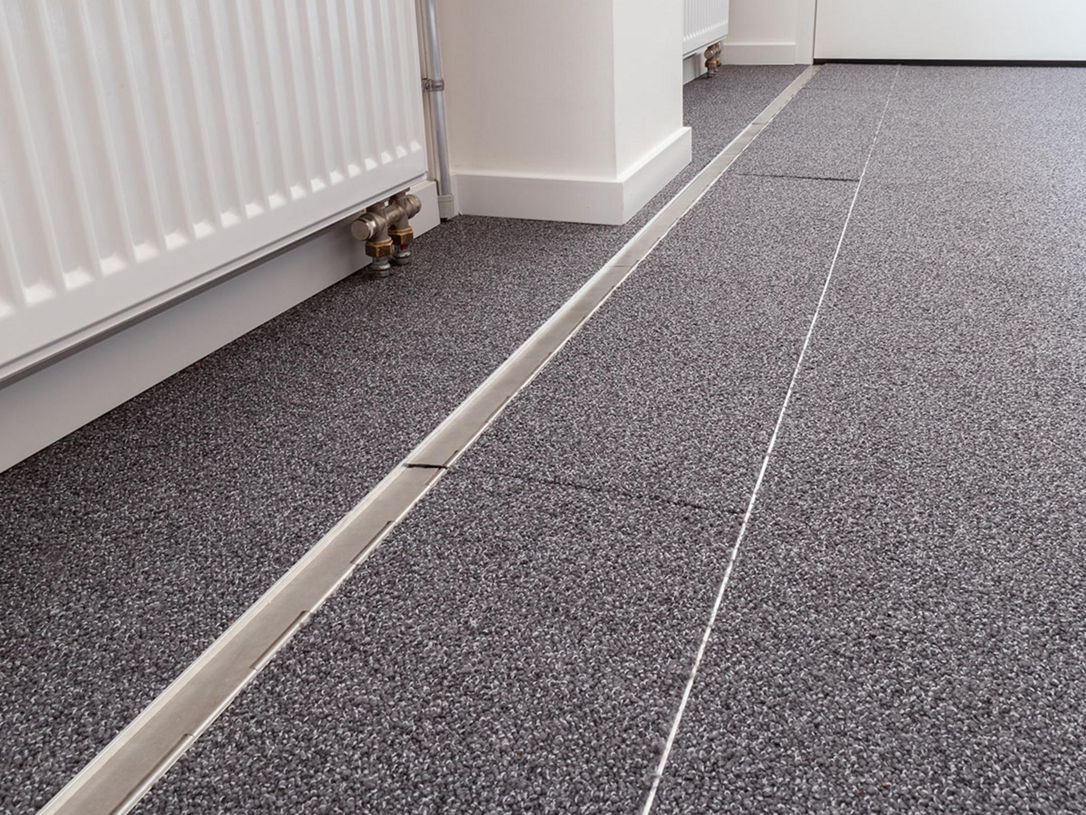 Das in den Boden eingelassene Kanalsystem für Kabel, geschlossen, in einem Büro. Es ist sehr unauffällig.