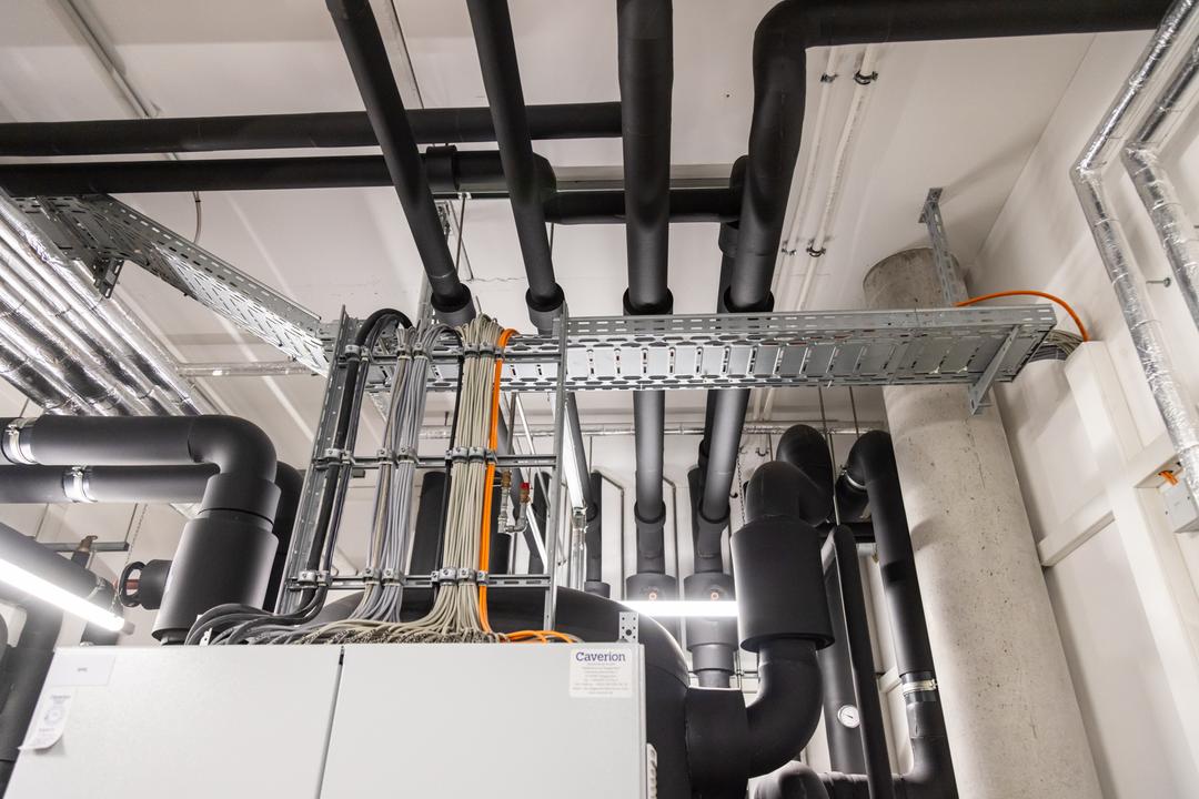 Verteilerkasten im Anschnitt mit anschließenden Kabelleitern und Kabelrinnen, die Kabel tragen.
