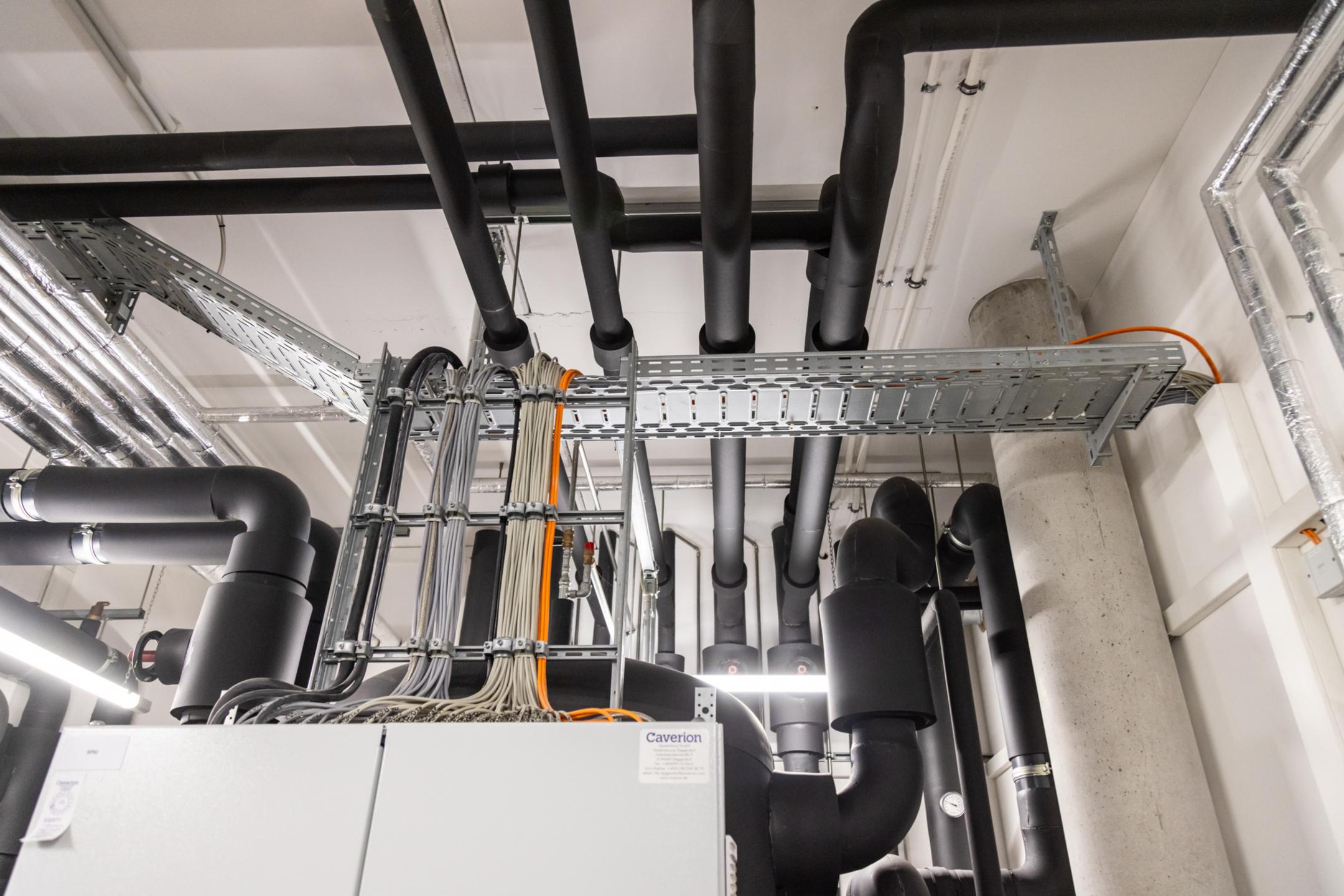 Verteilerkasten im Anschnitt mit anschließenden Kabelleitern und Kabelrinnen, die Kabel tragen.
