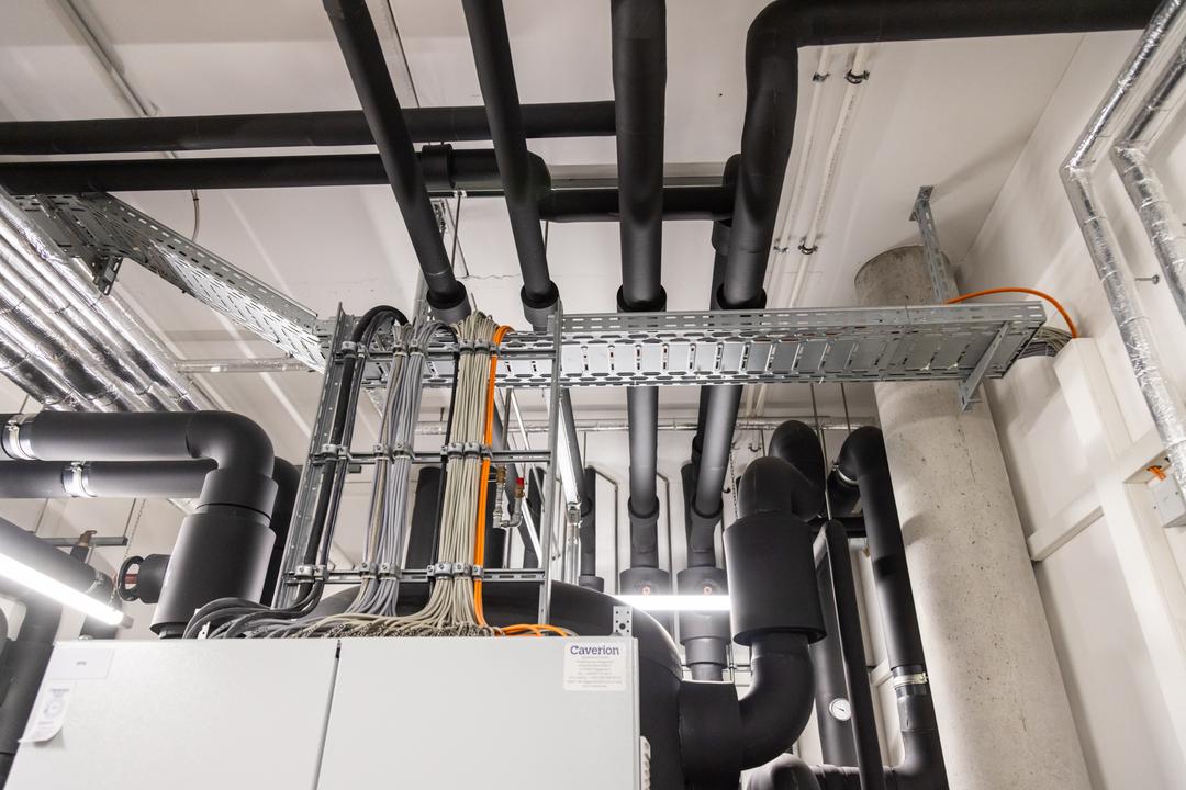 Verteilerkasten im Anschnitt mit anschließenden Kabelleitern und Kabelrinnen, die Kabel tragen.
