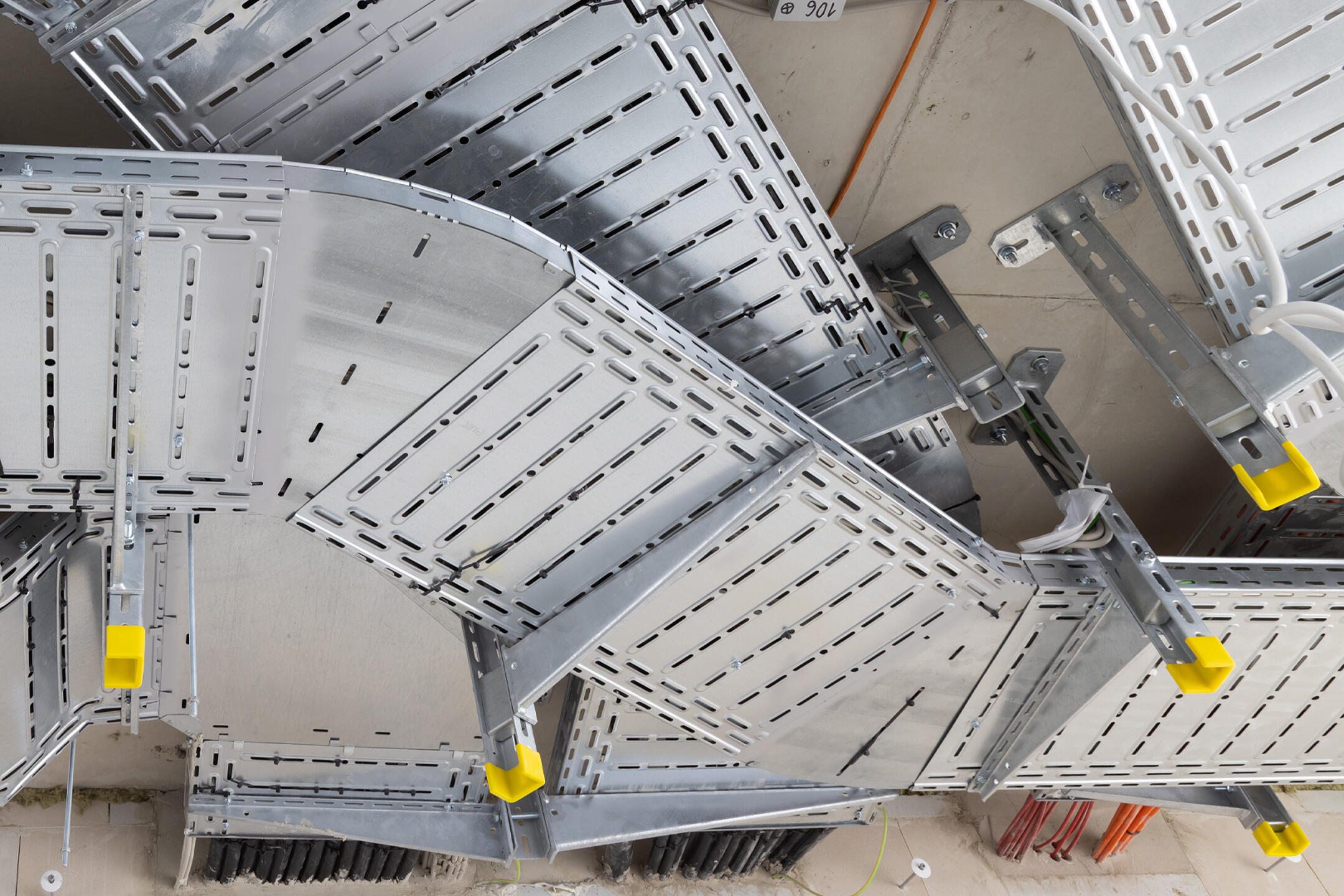 Verzweigtes Kabeltragsystem an der Decke mit gut sichtbaren variablen Rinnenbögen.