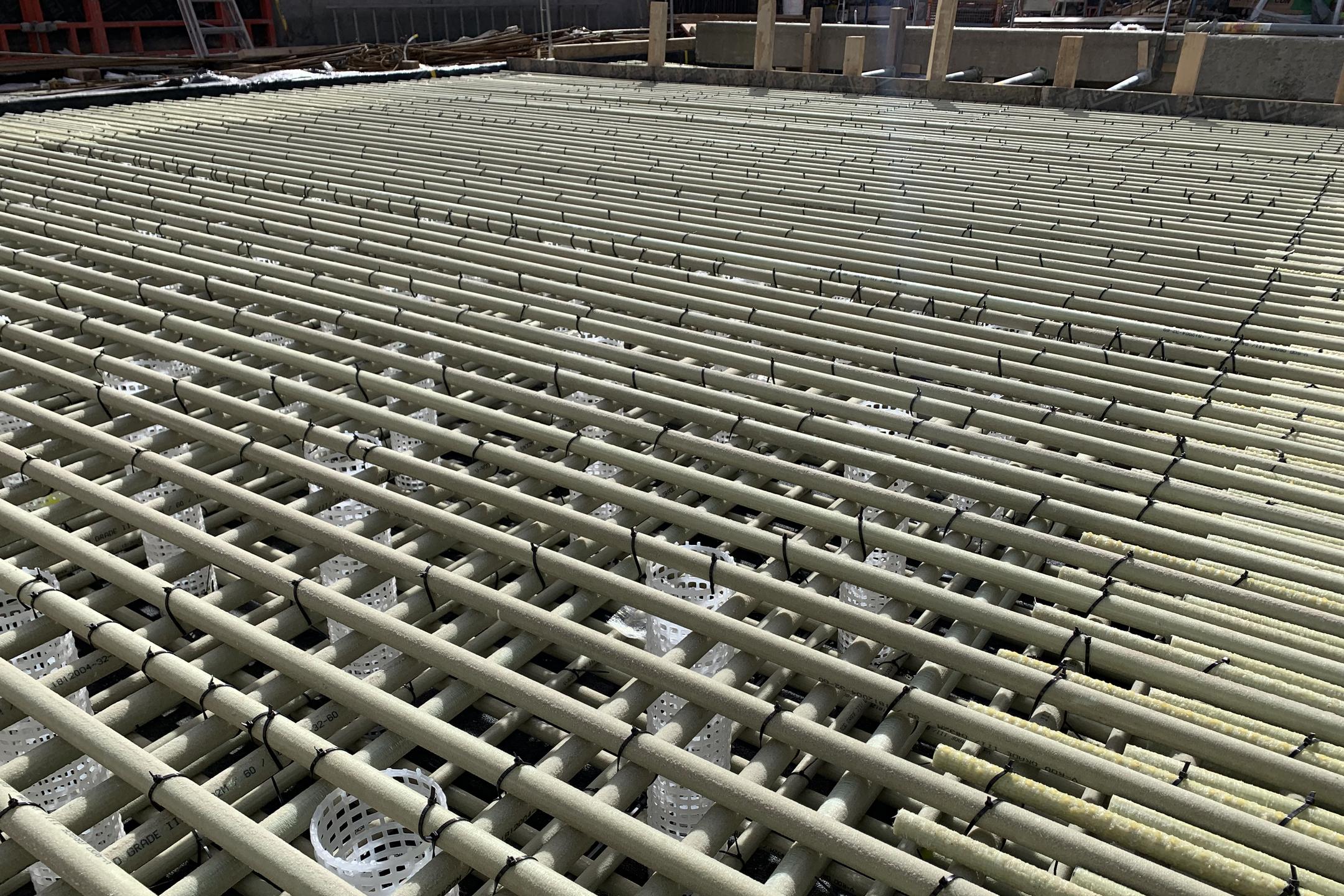 Baustelle mit kreuzweise verlegter Glasfaserkunststoffbewehrung und weißen Abstandshaltern