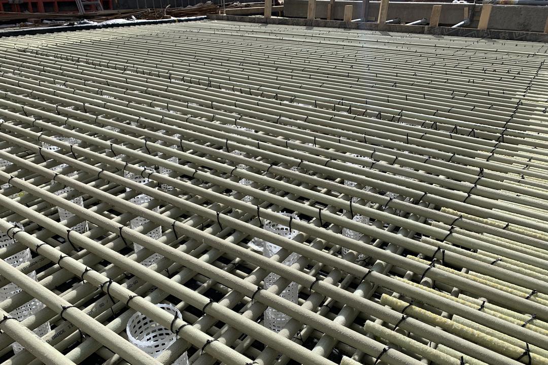 Baustelle mit kreuzweise verlegter Glasfaserkunststoffbewehrung und weißen Abstandshaltern