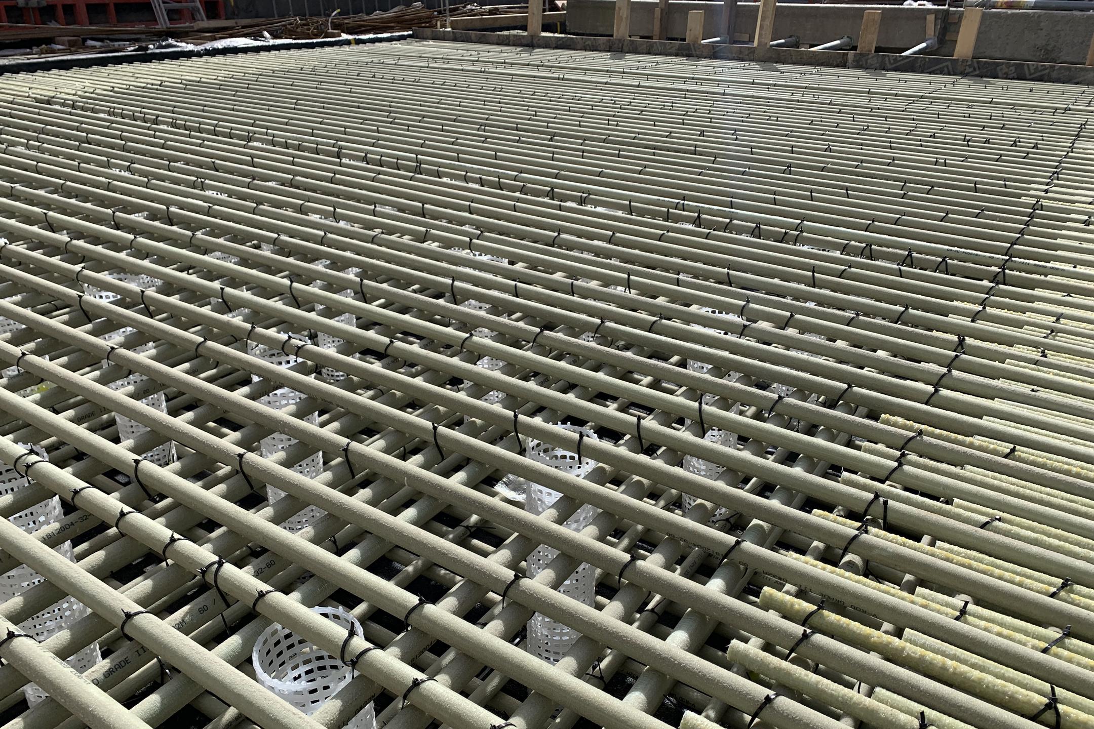 Baustelle mit kreuzweise verlegter Glasfaserkunststoffbewehrung und weißen Abstandshaltern