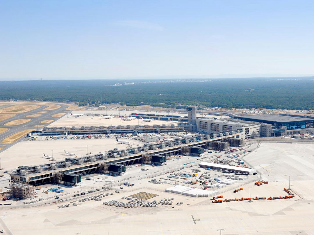 Blick auf das in Konstruktion befindliche Terminal 3 des Frankfurter Flughafens. Im Hintergrund breitet sich bis an den Horizont Wald aus.