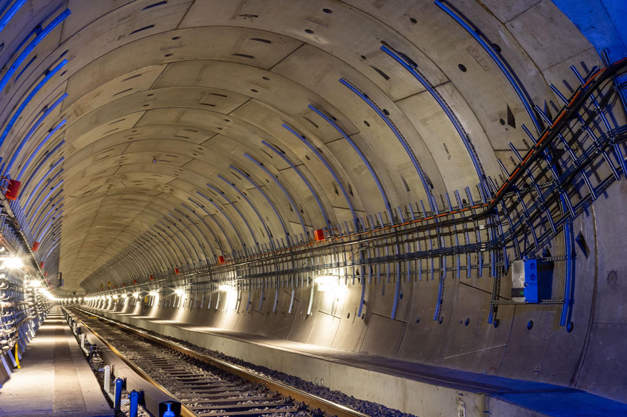 Moderne U-Bahn-Tunnelansicht mit beleuchteten Gleisen und Kabelanlagen