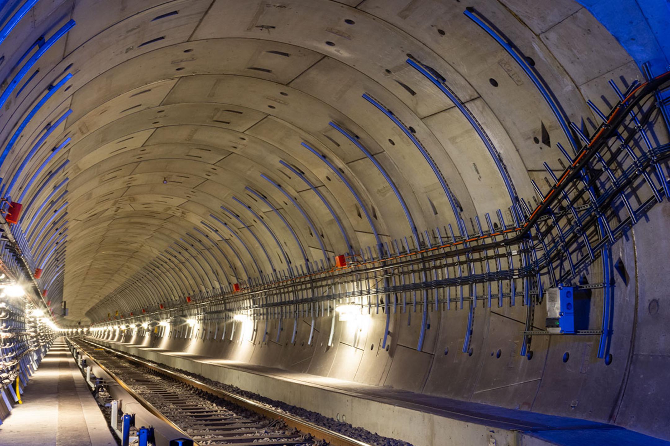 Moderne U-Bahn-Tunnelansicht mit beleuchteten Gleisen und Kabelanlagen