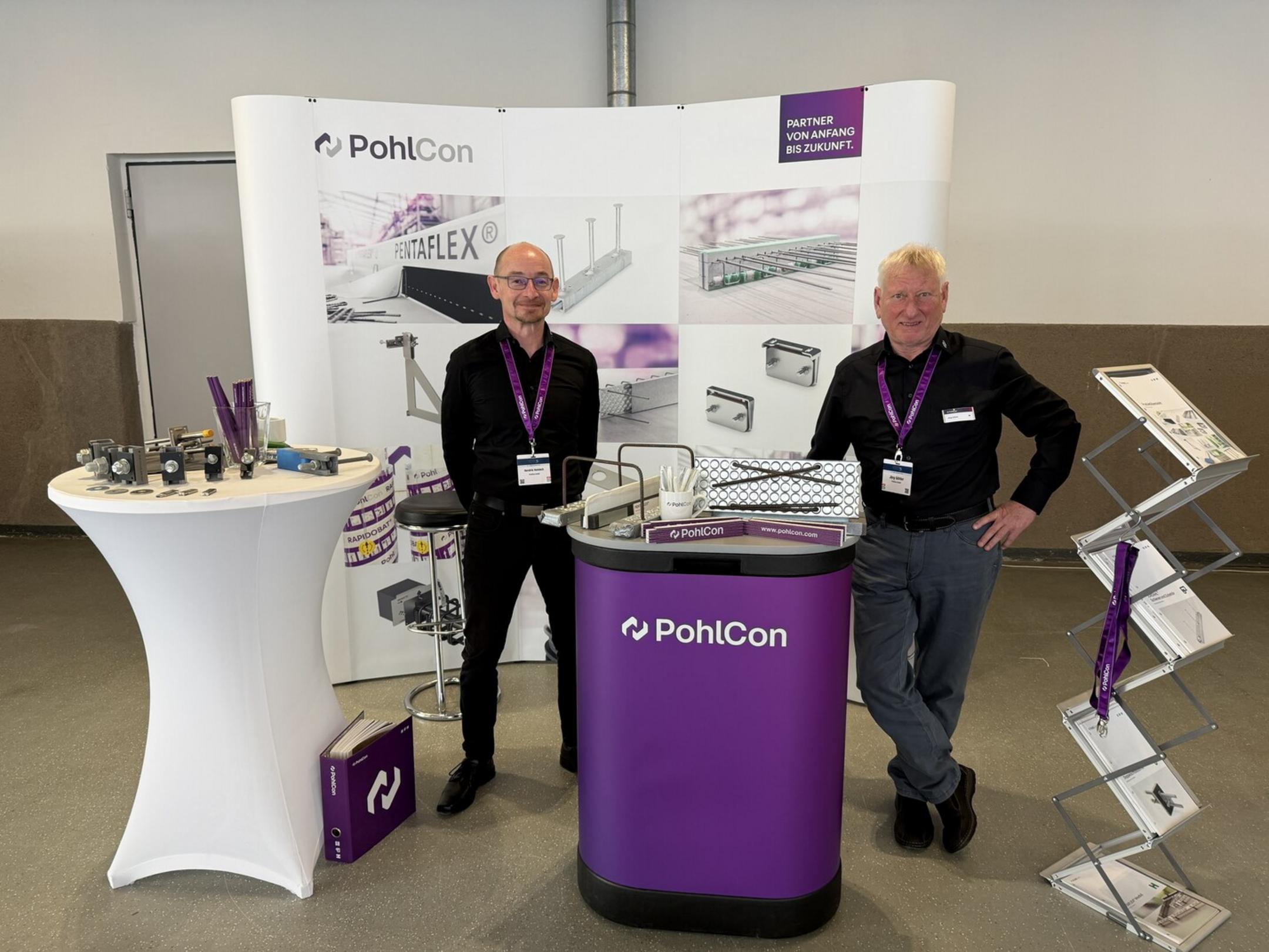 Messestand mit Schriftzug PohlCon und 2 Mitarbeitern sowie Ausstellungsstücken