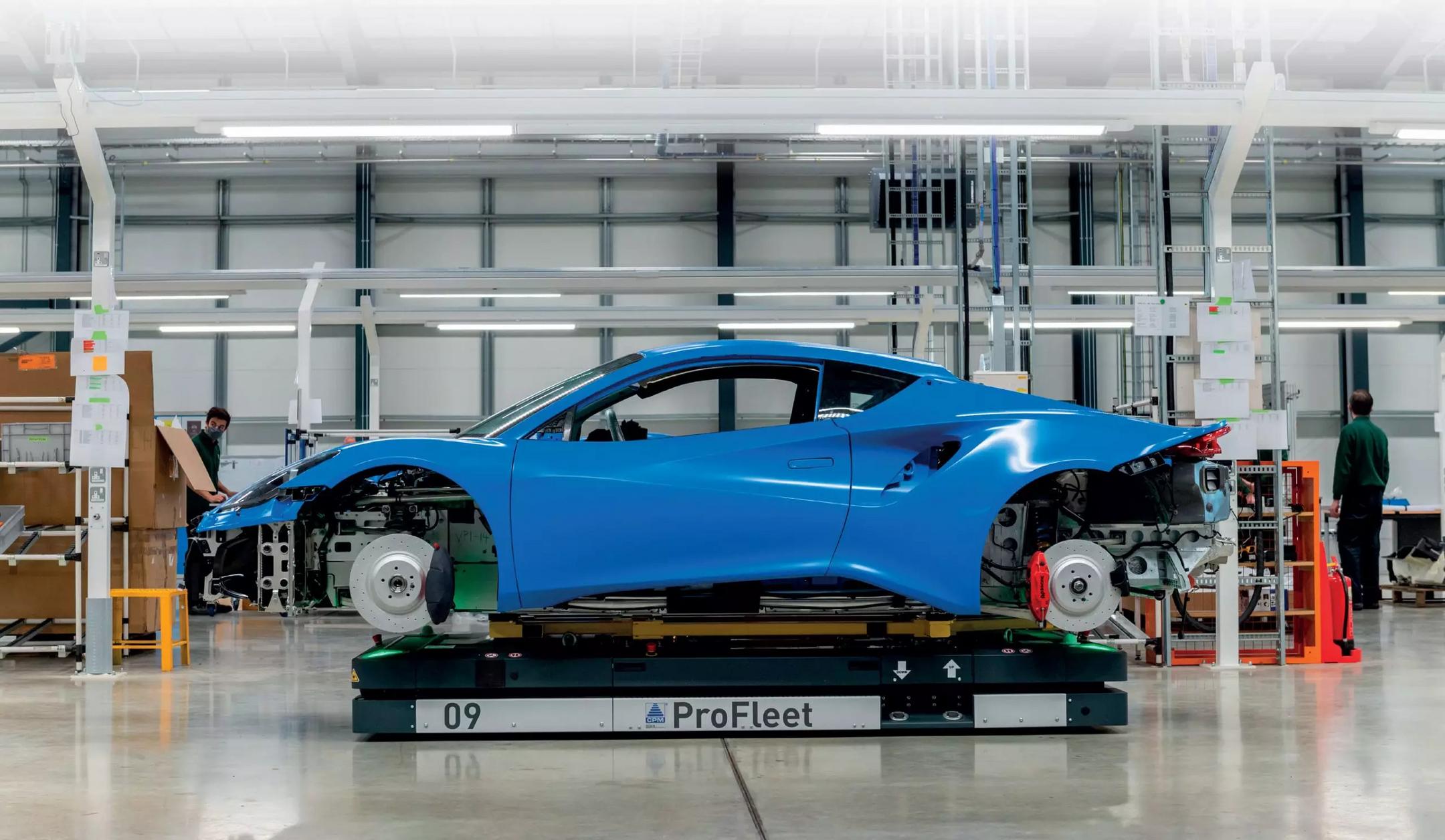 Automatisierter Transportroboter bewegt eine blaue Fahrzeugkarosserie in einer modernen Fertigungshalle