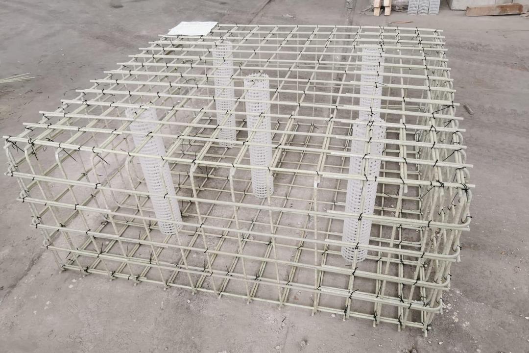Gitterstruktur aus Glasfaserkunststoffbewehrungsstäben mit 5 Kunststoffzylindern auf einer Betonfläche liegend