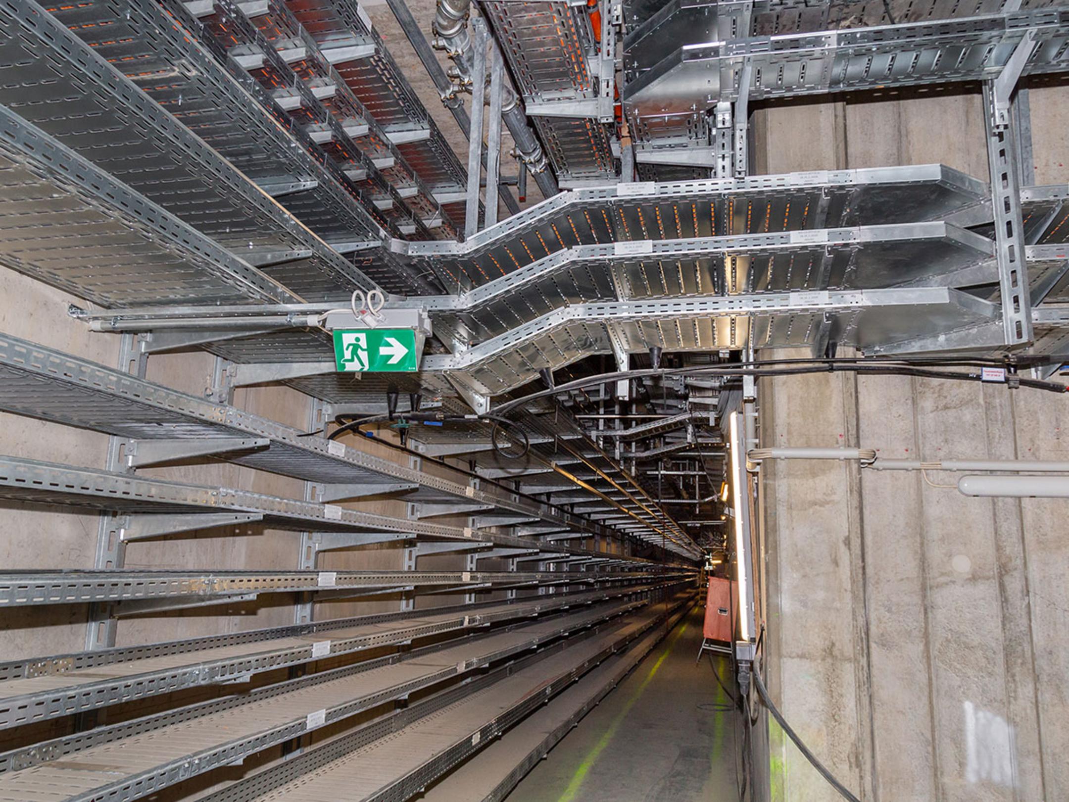 Ein geordnetes Wirrwarr von Kabelführungstrassen an einer anderen Stelle im Inneren des neuen Terminals, ohne Kabel.