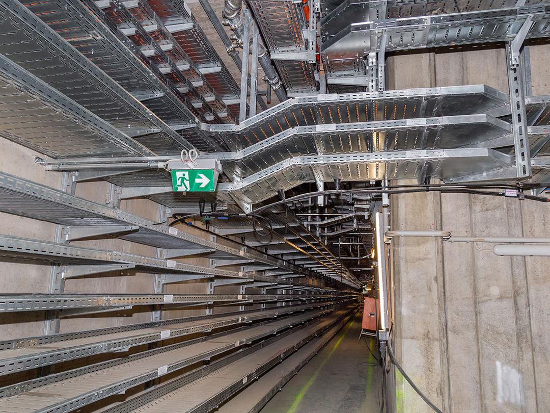 Ein geordnetes Wirrwarr von Kabelführungstrassen an einer anderen Stelle im Inneren des neuen Terminals, ohne Kabel.