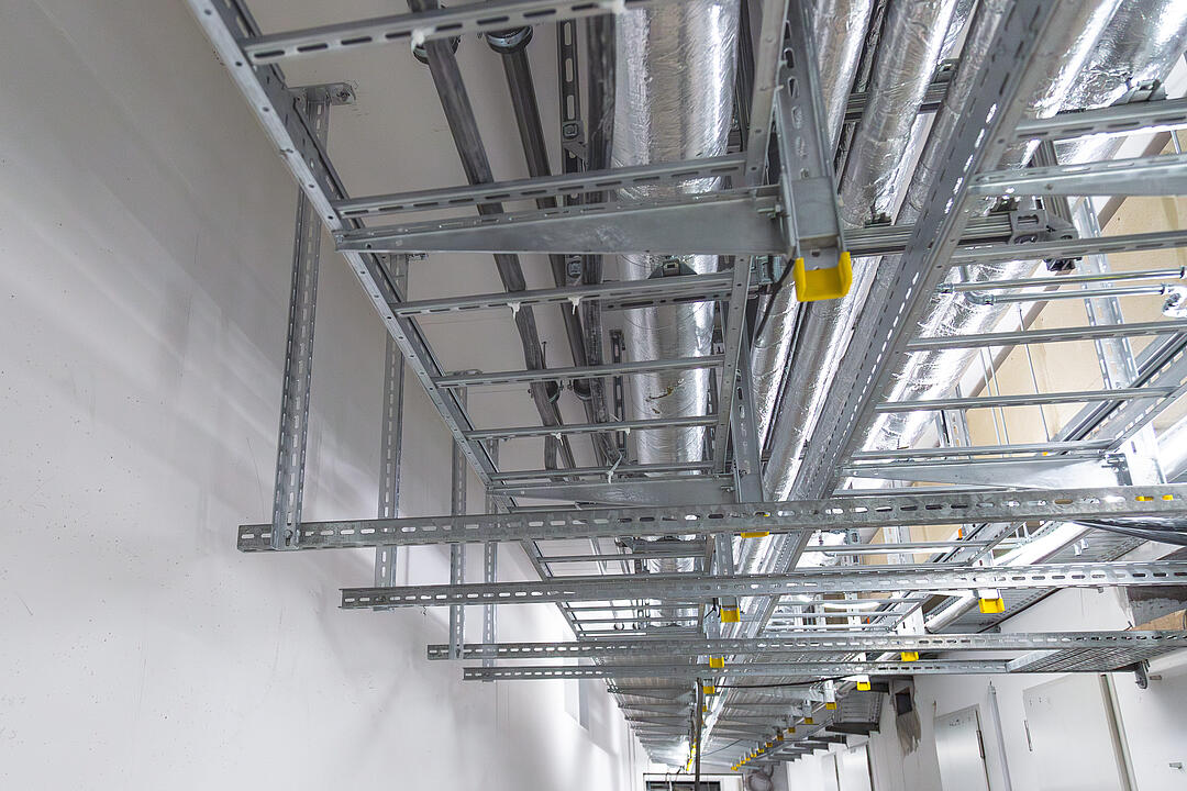 Betonrohbau mit an der Decke montierten Kabeltrassen