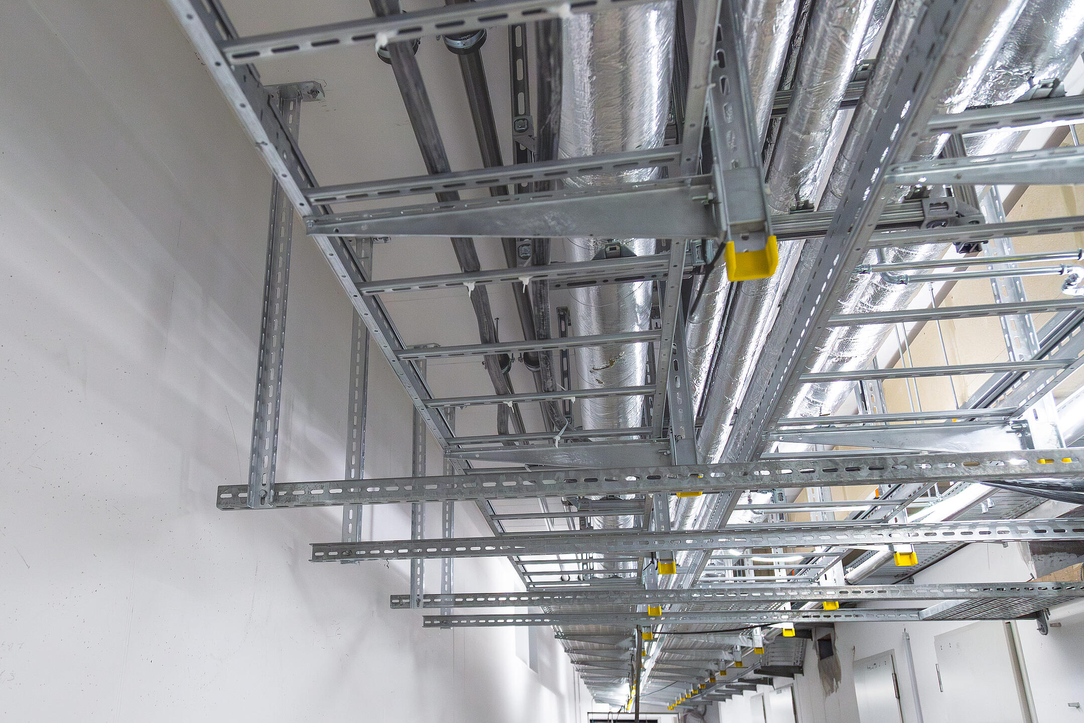 Betonrohbau mit an der Decke montierten Kabeltrassen