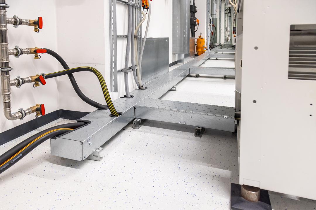 Detailansicht begehbarer Bodenkanal mit Maschine im Anschnitt.