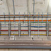 Farbcodierte Kabel befestigt an der Betonwand eines Bahntunnels, sauber organisiert und sicher befestigt