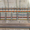 Farbcodierte Kabel befestigt an der Betonwand eines Bahntunnels, sauber organisiert und sicher befestigt