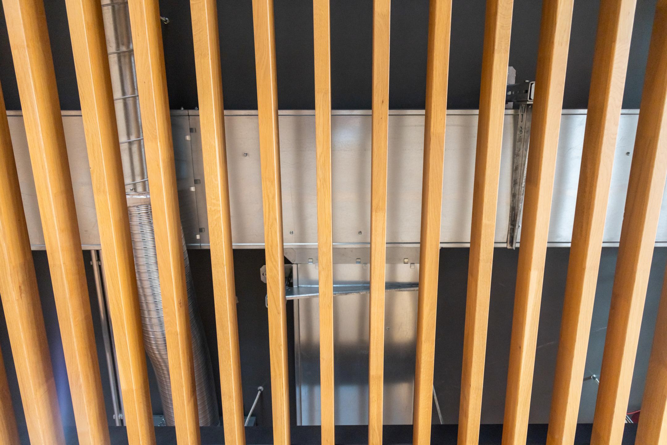 Blick nach oben auf eine ungelochte Kabelrinne hinter einer Holzverkleidung.
