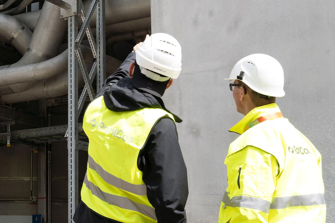 Zwei Monteure begutachten die Technische Gebäudeausrüstung eines Gebäudes