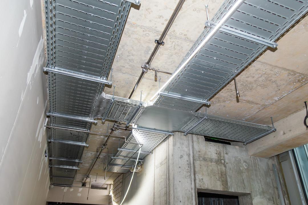 An der Decke montierte Kabeltrassen mit Kreuzung und Lichtschlauch zur Baustellenbeleuchtung