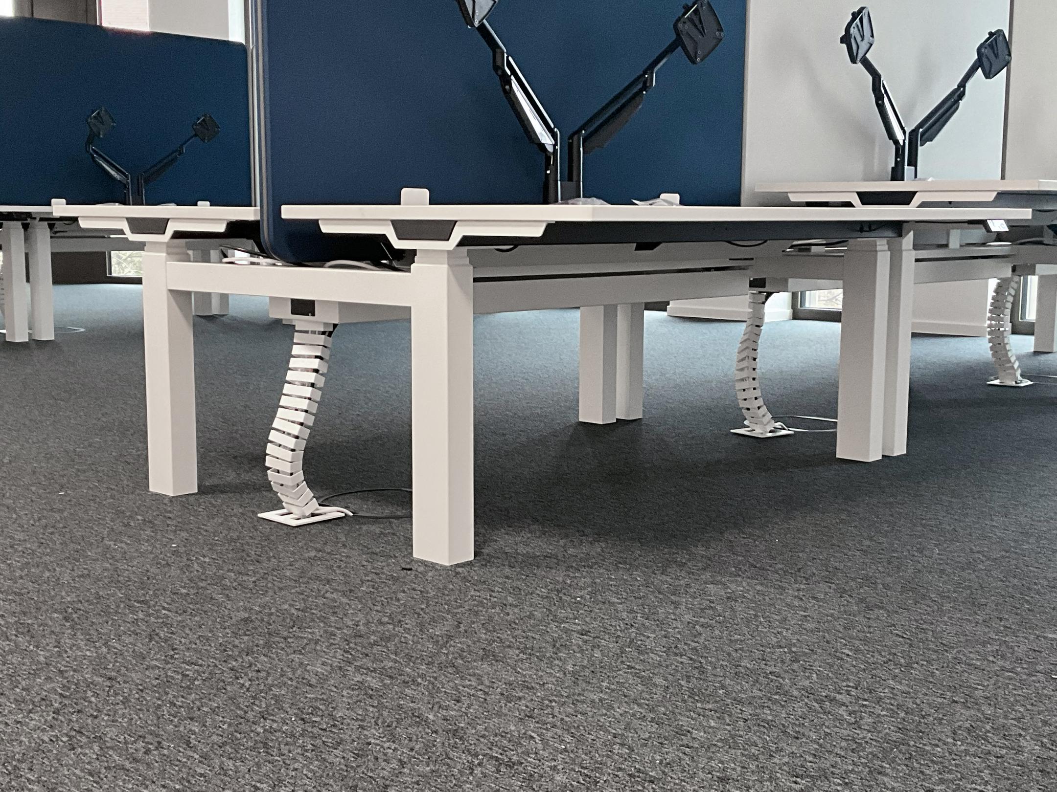 Büro mit Schreibtischen und Monitoren, im Boden befinden sich Klappdeckeleinheiten.