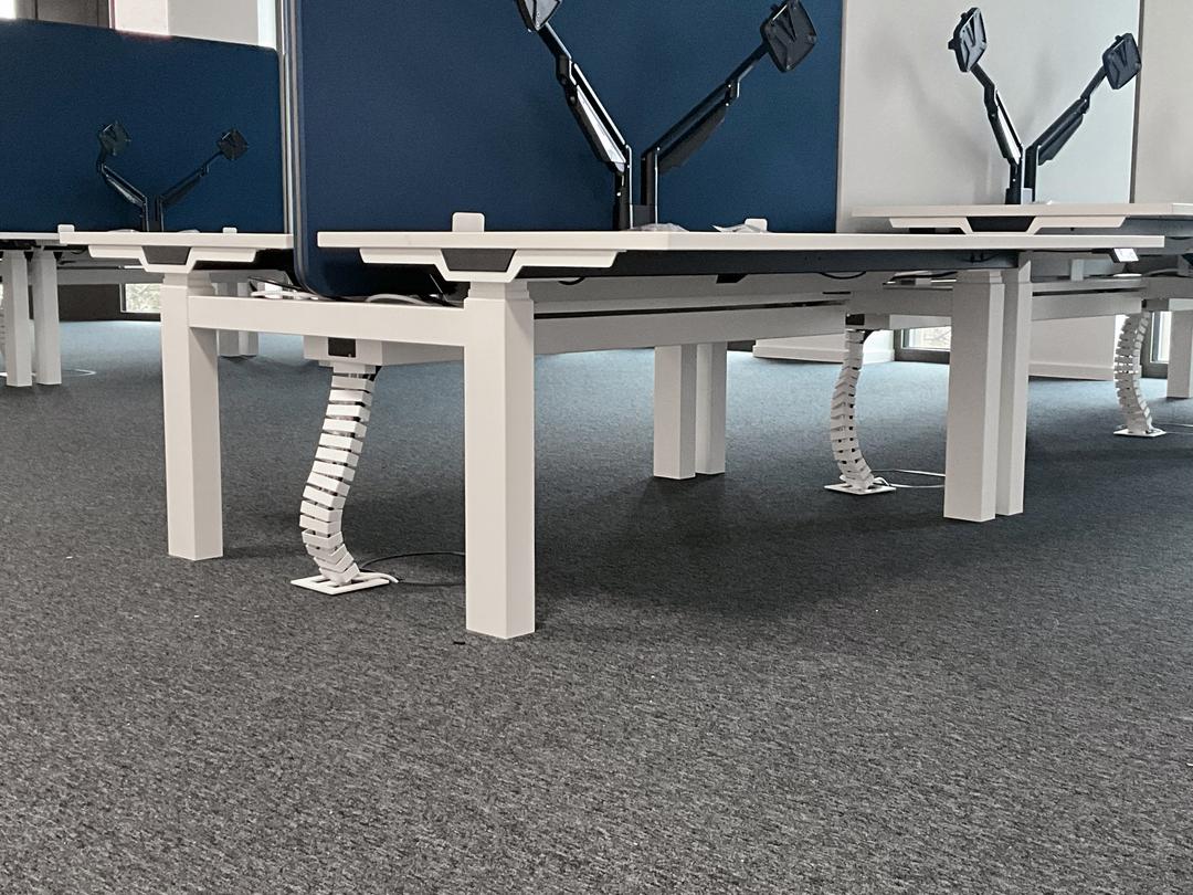Büro mit Schreibtischen und Monitoren, im Boden befinden sich Klappdeckeleinheiten.