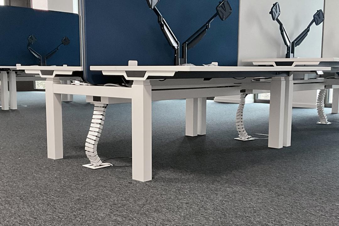 Büro mit Schreibtischen und Monitoren, im Boden befinden sich Klappdeckeleinheiten.