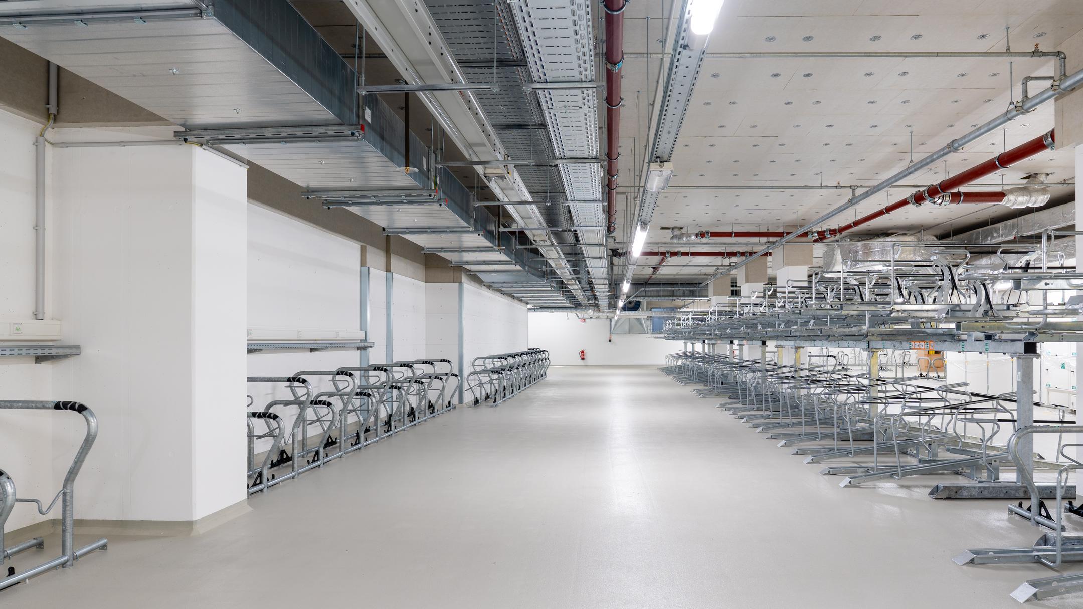 Tiefgarage mit mehreren Fahrradstellplätzen, Kabelrinnen an der Decke.