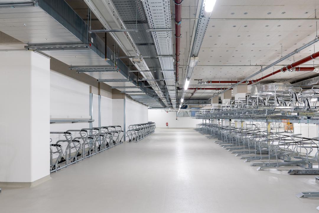 Tiefgarage mit mehreren Fahrradstellplätzen, Kabelrinnen an der Decke.