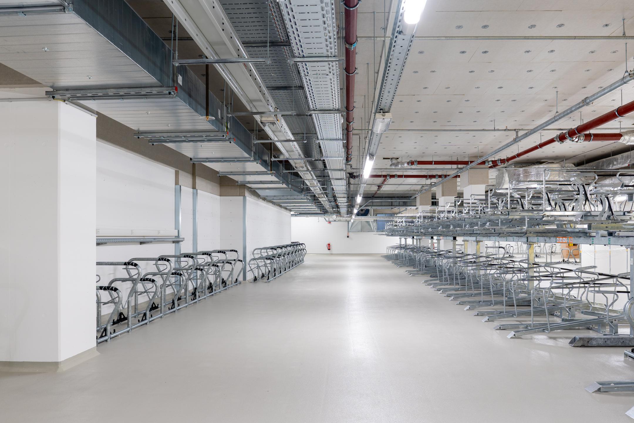 Tiefgarage mit mehreren Fahrradstellplätzen, Kabelrinnen an der Decke.