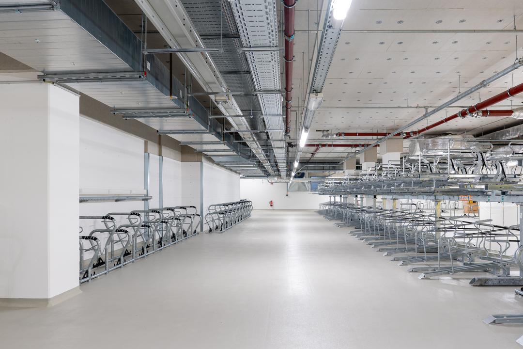 Tiefgarage mit mehreren Fahrradstellplätzen, Kabelrinnen an der Decke.