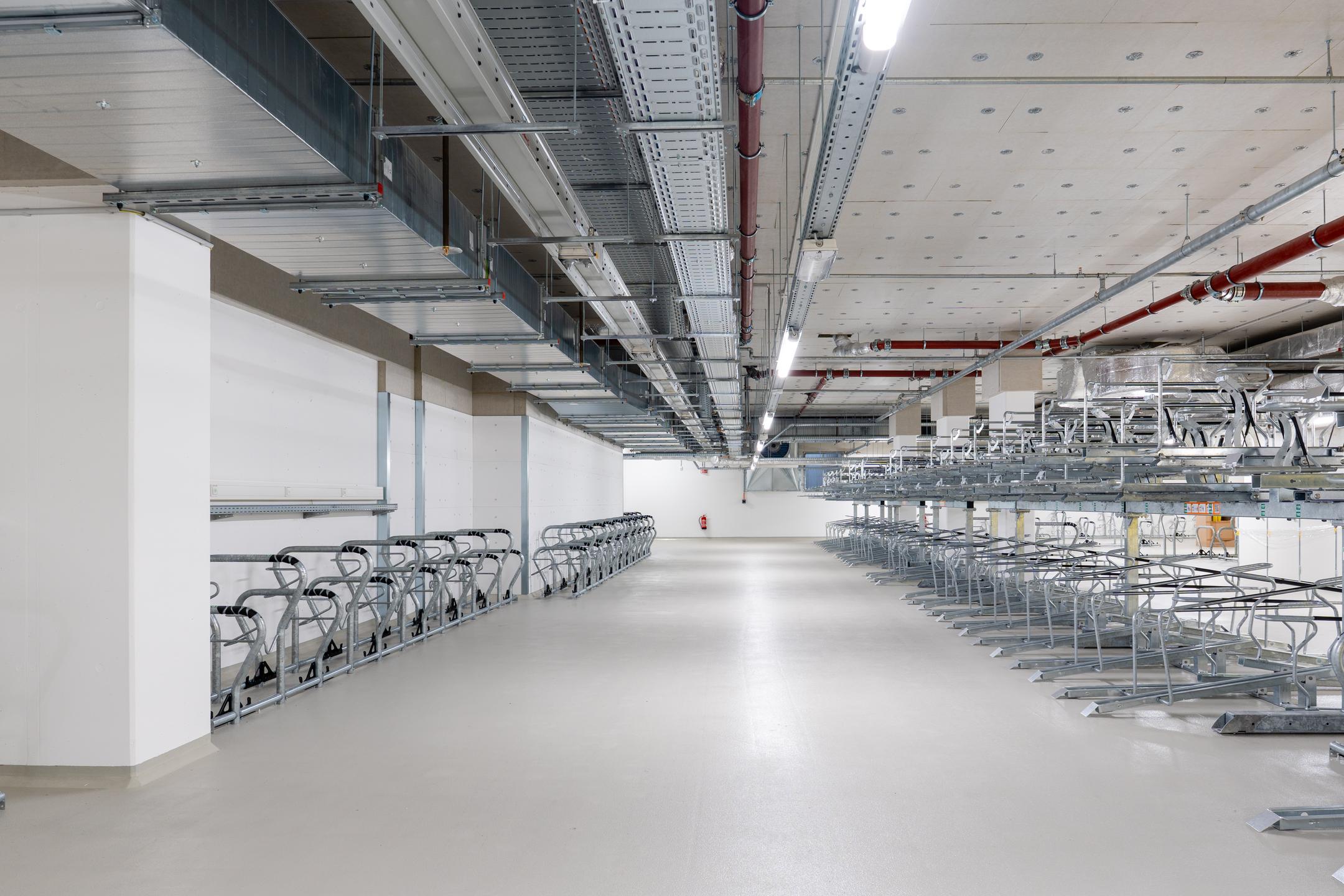 Tiefgarage mit mehreren Fahrradstellplätzen, Kabelrinnen an der Decke.