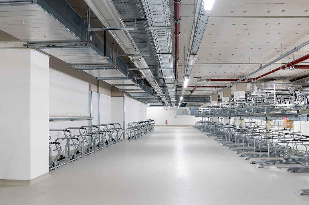 Tiefgarage mit mehreren Fahrradstellplätzen, Kabelrinnen an der Decke.