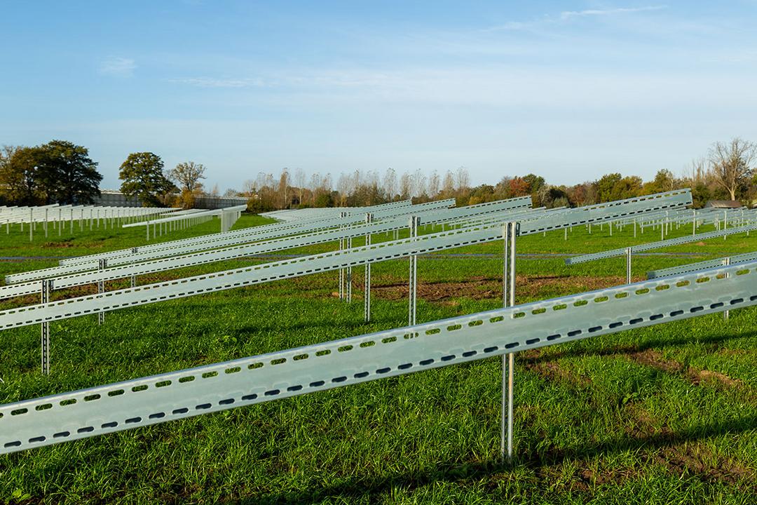 Die Unterkonstruktionen für Solarpanele auf einer grünen Wiese mit blauem Himmel