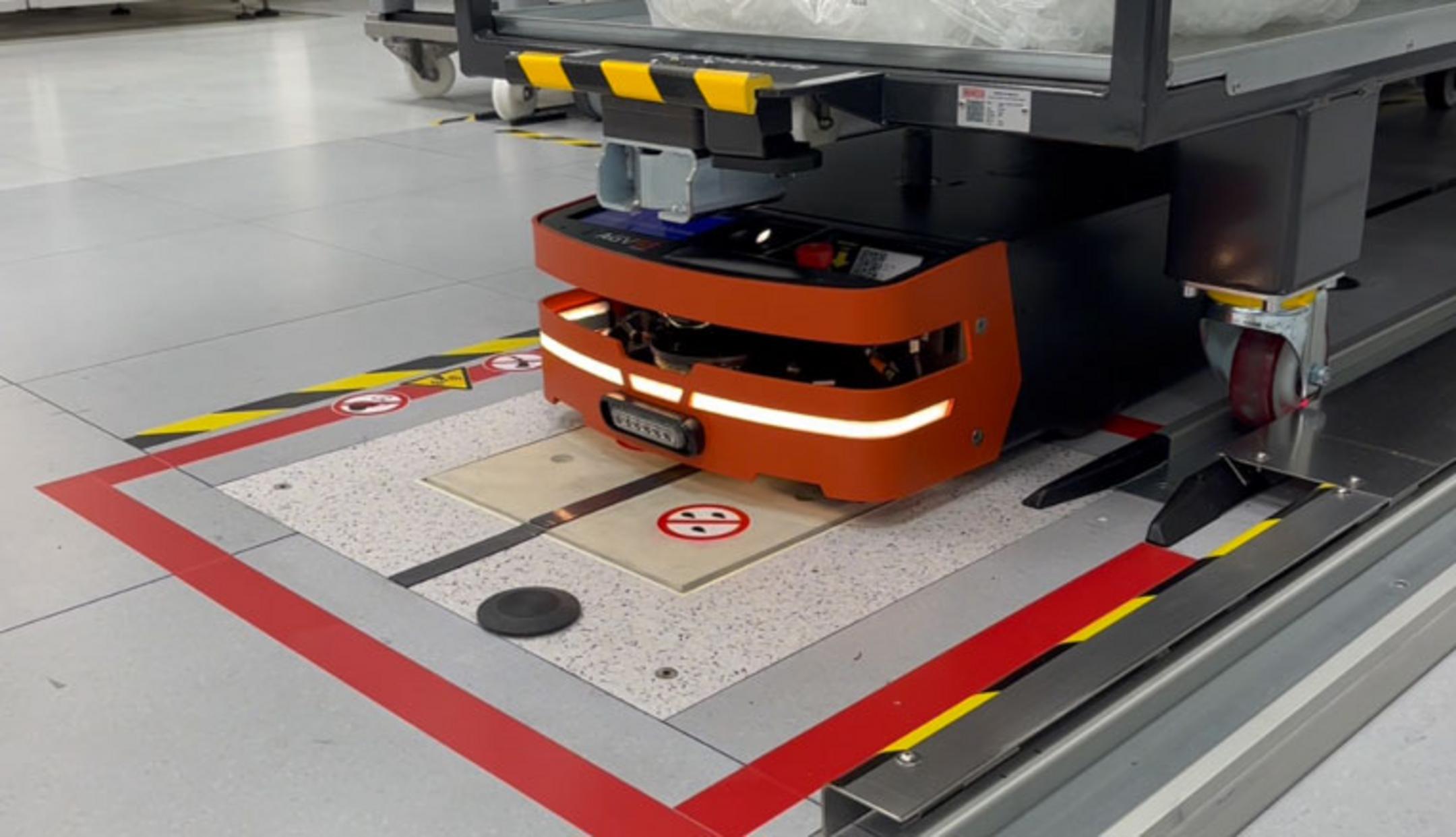 Die in den Boden eingelassene Wireless Charging Protection System (WCPS)-Ladeinfrastruktur von Pohlcon in einem Fabrikgebäude in Nahaufnahme.