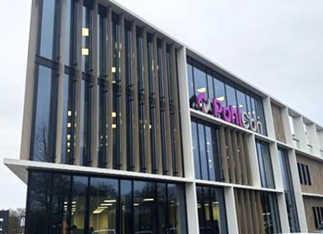 Blick auf die Fassade eines modernen Bürogebäudes. Pohlcon als Wort- und Bildmarke sind als Schriftzug oben am Gebäude angebracht.