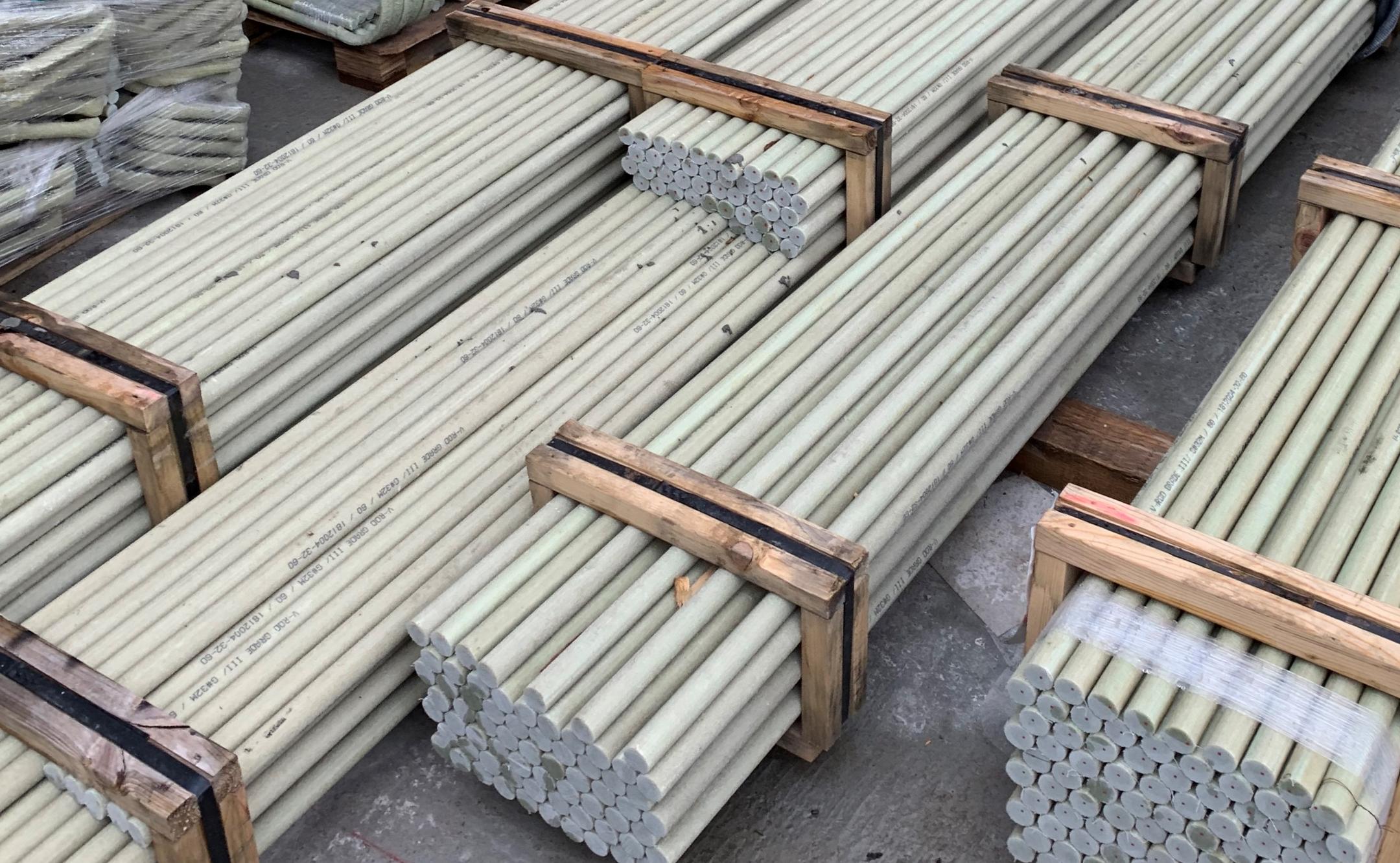 Gestapelte Bündel von Glasfaserkunststoffbewehrungsstäben, gelagert in Holzrahmen