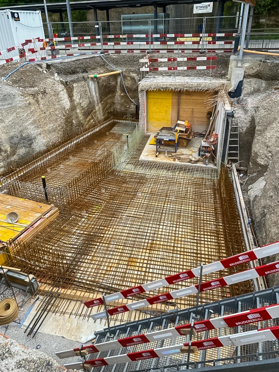 Draufsicht auf Baustelle mit Glasfaserkunststoffbewehrungsstäben umgeben von Absperrungen und Aushub