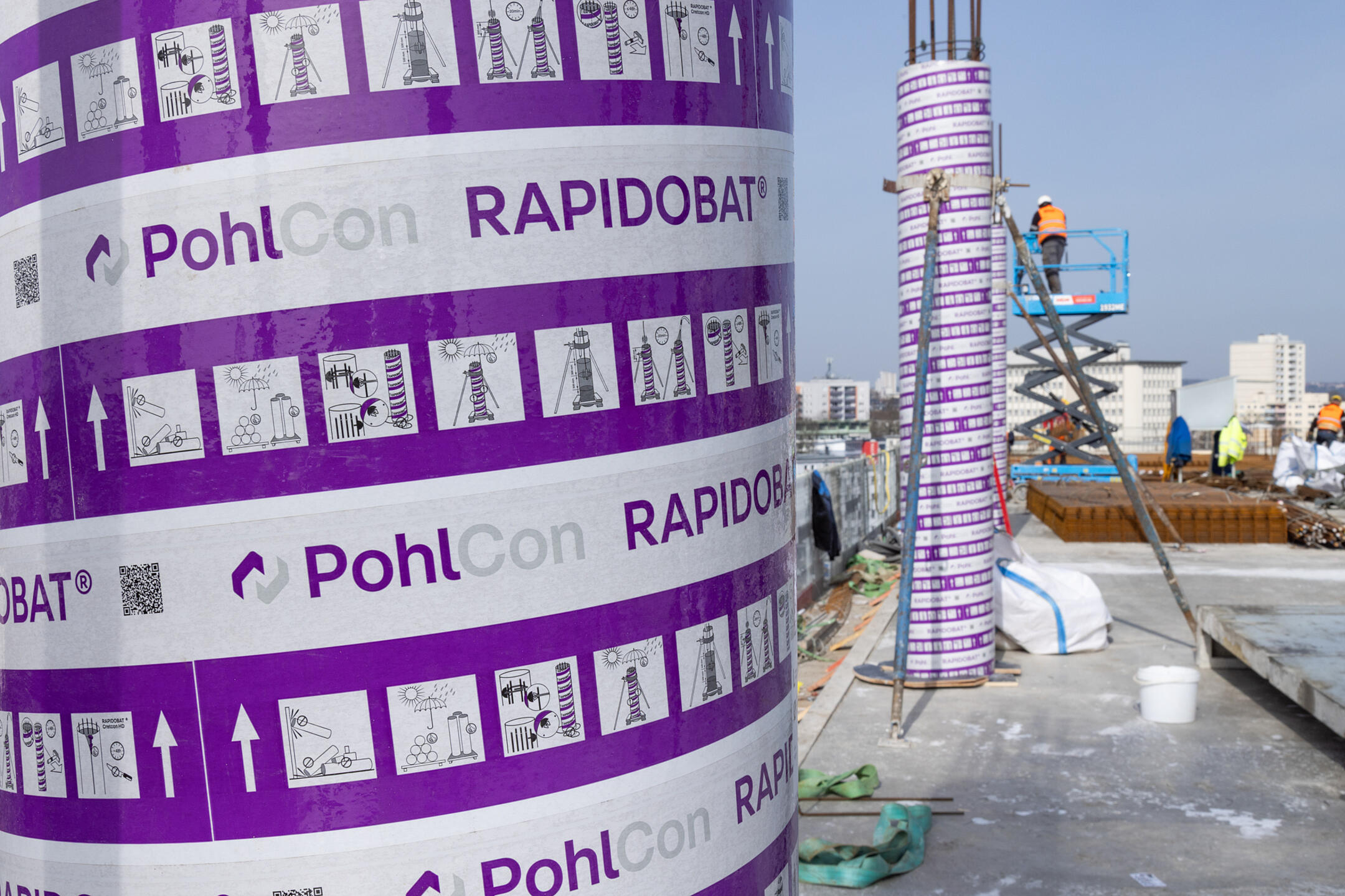 Detailansicht Schalungskörper mit Aufschrift "PohlCon Rapidobat", im Hintergrund Baustelle in Rohbauphase
