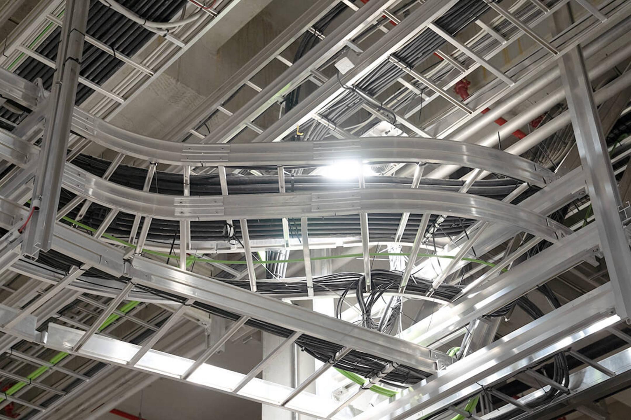 Verzweigtes System aus Kabelleitern an der Decke montiert und mit zentraler Lichtquelle