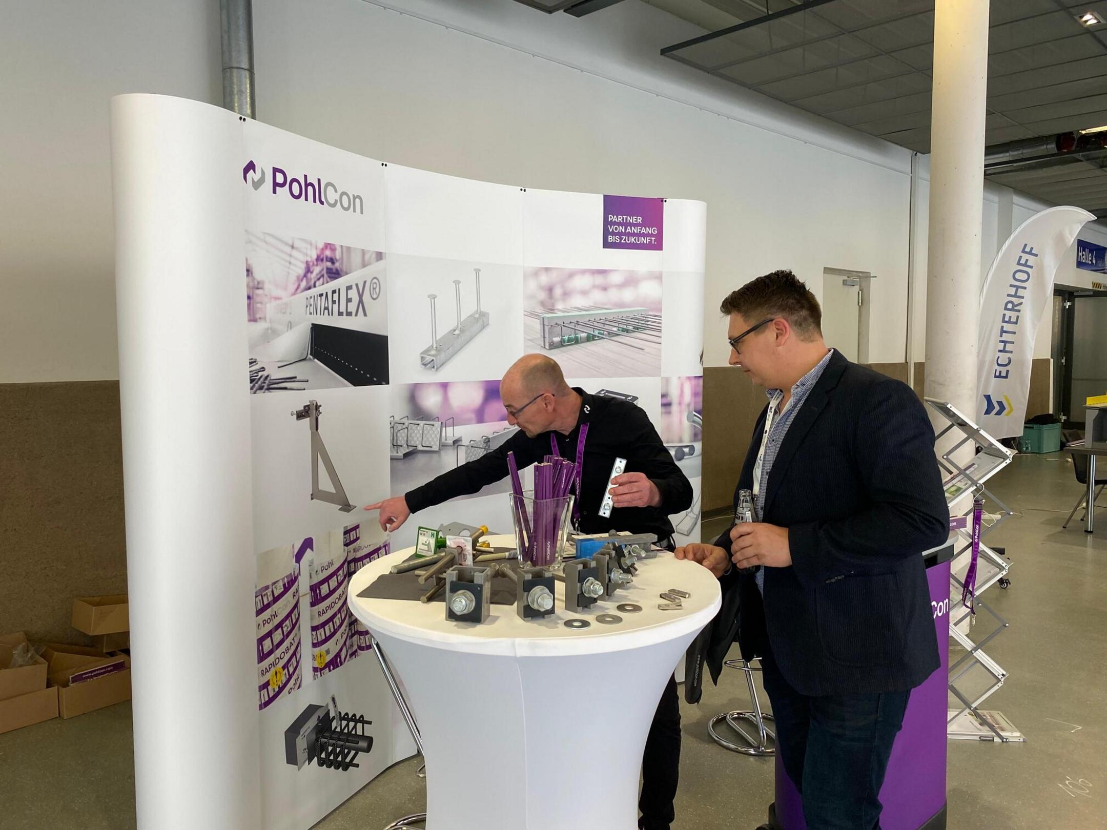 Messestand mit Schriftzug PohlCon, Mitarbeiter und Besucher sowie Ausstellungsstücken